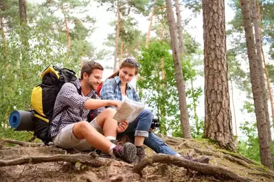 Happy couple reading a map on a hike together.