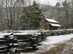 An historic cabin covered in snow in Cades Cove in winter.