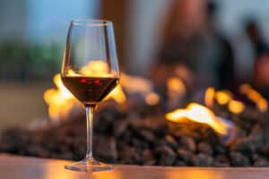 glass of red wine in front of fire pit