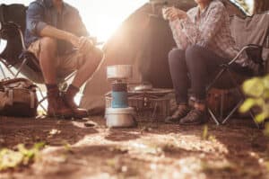 couple sitting in front of tent while camping